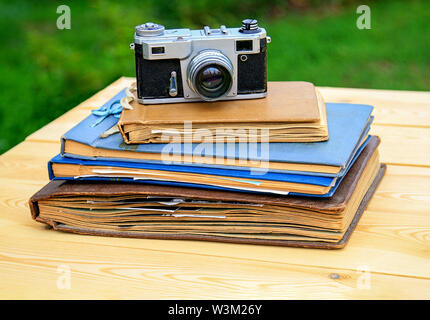 Vieux albums photo ancien appareil photo sur une table en bois dans le jardin d'été. Banque D'Images