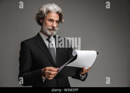 Image homme d'adultes portant costume noir formelle tenant les cartes papier sur fond gris isolé Banque D'Images