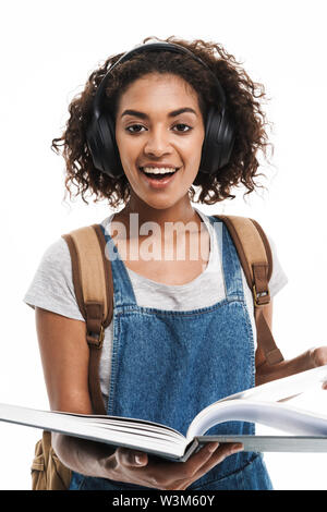 Image de l'african american woman Gai Écoute de la musique avec des écouteurs lors de la lecture de livre plus isolé sur fond blanc Banque D'Images