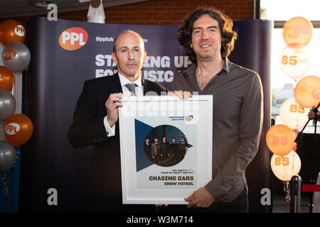 À l'embargo MERCREDI 17 JUILLET 0001 DIRECTEUR GÉNÉRAL d'PPLUK Peter Leatham (à gauche) présente le leader de Snow Patrol Gary Lightbody avec le prix de la plupart des chanson du 21e siècle, en fonction de société de gestion de la musique PPL pour sa bande son dossier, Chasing Cars, à l'Oxo Tower, London. Banque D'Images