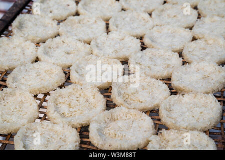 Close-up de riz collant enfoncé dans rond plat gâteaux séchant au soleil sur un plateau de bambou fait main à Luang Prabang, Laos. Banque D'Images