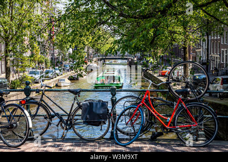 Amsterdam, Pays-Bas, le centre-ville, vieille ville, roues, stationné sur une balustrade d'un pont sur un canal, Banque D'Images