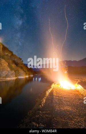 La Voie lactée à côté du feu de camp sur la rivière Banque D'Images