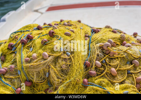 Tas de filets de pêche jaune sur un pont de bateau pêcheur dans l'île de Zante, Grèce Banque D'Images