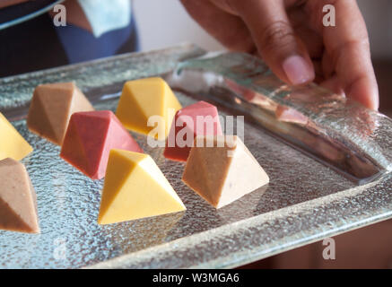 Chocolat pralines vegan colorés en verre sur plateau. Banque D'Images
