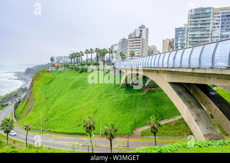 Vue sur océan Pacifique avec Puente Villena Mellizo Rey, un pont à Malecón de la Reserva, Parque del Amor en arrière-plan, Miraflores, Lima, Pérou. Banque D'Images