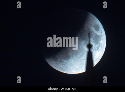 Schwerin, Allemagne. 16 juillet, 2019. La pleine lune, qui a déjà partiellement entré l'ombre de la terre à ce moment, brille au-dessus du château de Schwerin. Les badauds peuvent observer une éclipse lunaire partielle sur l'Allemagne. Entre 22h le mardi et 13h le mercredi des parties de la terre se trouvent dans le noyau de la ombre de la terre et la lune brillent dans le ciel rouge rouille. Credit : Jens Buettner/dpa-Zentralbild/dpa/Alamy Live News Banque D'Images