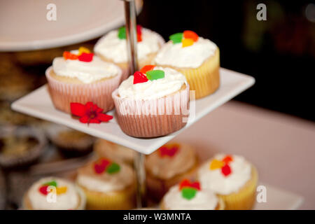 Belle vanilla cupcakes avec glaçage blanc et coloré bonbons jujube Banque D'Images