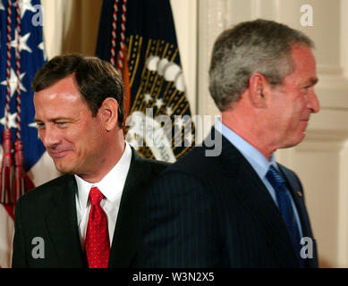 Washington, DC - 29 septembre 2005 -- John Glover Roberts, Jr., gauche, passe le président des États-Unis George W. Bush, droite, comme il se déplace vers le pupitre pour faire des remarques à la suite d'être assermentés à titre de la 17e Juge en chef des États-Unis par le juge John Paul Stevens associé dans l'East Room de la Maison Blanche à Washington, DC Le 29 septembre 2005. Credit : Ron Sachs/CNP | conditions dans le monde entier Banque D'Images