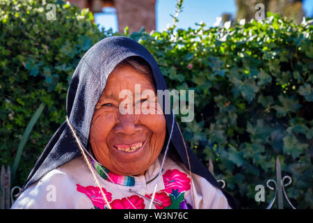 Portrait de la femme âgée autochtone quechua portant des vêtements péruviens traditionnels, tricotage, sourire, île Amantani, Lac Titicaca, Pérou Banque D'Images