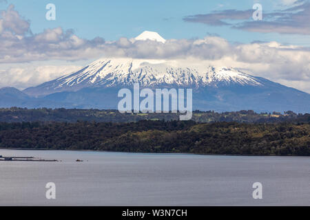 L'incroyable sommet enneigés volcan Osorno au-dessus des eaux et les nuages à partir de Puerto Plata, les arbres à l'intérieur de la forêt et les nuages d'un paysage Banque D'Images