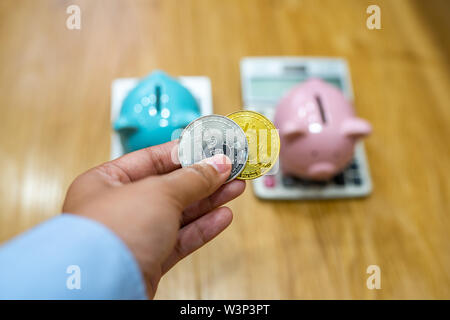 Femme main tenant à mettre en bitcoin piggy bank Banque D'Images