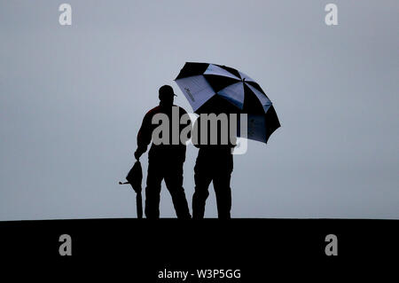 Spectateurs sous un parapluie au cours de l'aperçu jour 4 de l'Open Championship 2019 au Club de golf Royal Portrush. Banque D'Images