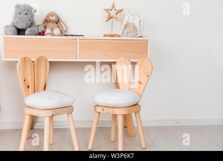 2 chaises avec oreilles de lapin dans la chambre pour enfants et une table avec des jouets Banque D'Images