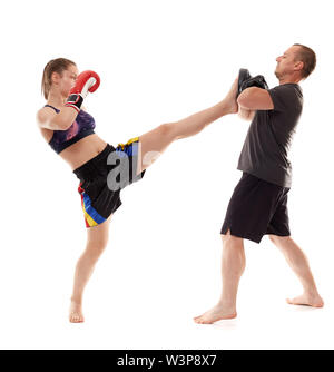 Jeune femme kickboxer sparring avec son entraîneur sur fond blanc Banque D'Images