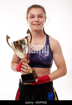 Happy girl gagnant du concours de kickboxing, tenant la coupe d'or Banque D'Images