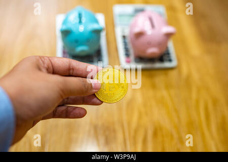 Close up of businesswoman holding piggybank derrière bitcoin avec Banque D'Images