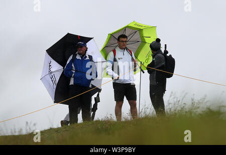 Les spectateurs à l'abri de la pluie au cours de l'aperçu jour 4 de l'Open Championship 2019 au Club de golf Royal Portrush. Banque D'Images