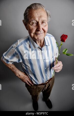 Hauts détient une rose rouge dans sa main, symbole photo l'amour, la romance, studio shot, Allemagne Banque D'Images