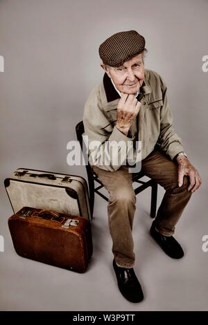 Siège principal avec vieille valise sur une chaise, image symbolique de quitter, désir, studio shot, Allemagne Banque D'Images