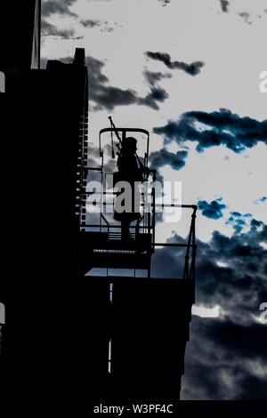 Piper sac jouant sur toit au coucher du soleil Banque D'Images