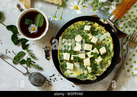 Arrière-plan de petit-déjeuner. Oeufs au plat avec des épinards, fromage feta sur table en pierre. Vue supérieure de la télévision mise de fond. Banque D'Images