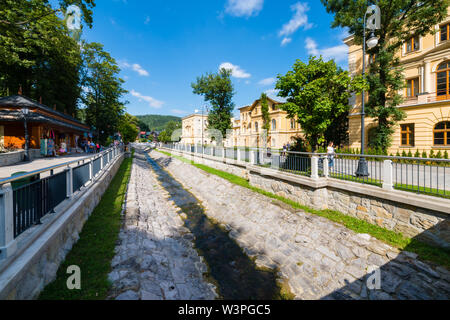 KRYNICA ZDROJ, Pologne - 23 août 2015 : Kryniczkanka rivière qui coule le long de la promenade piétonne de Krynica - très faible niveau d'eau de la rivière Banque D'Images