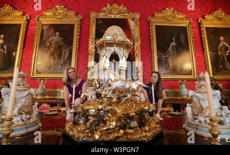 Une paire de Collection Royale employés à s'adapter à un classement parmi les loisirs d'un dîner de l'époque victorienne dans l'état de la salle à manger dotée d''une fontaine de l'Alhambra (centre) à l'exposition pour marquer le 200e anniversaire de la naissance de la Reine Victoria pour l'ouverture estivale du Buckingham Palace, Londres. Banque D'Images