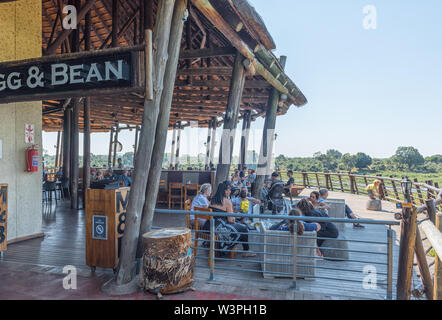 Le parc national Kruger, AFRIQUE DU SUD - 4 mai 2019 : un restaurant avec terrasse d'observation dans la basse Sabie Rest Camp dans le parc national Kruger. Les gens sont Banque D'Images