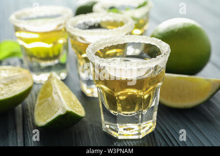 Tequila shots, sel, citron vert et menthe tranches sur la table en bois, gros plan Banque D'Images