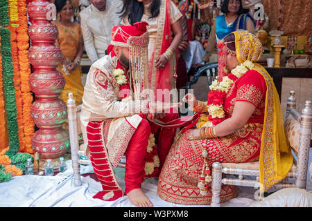 Une femme et un homme bagues change au cours d'une cérémonie de mariage traditionnelle hindoue dans un temple à Ozone Park, Queens, New York. Banque D'Images