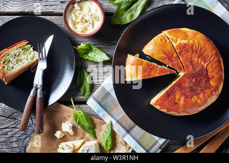 Les épinards et les haricots verts Tarte au fromage bleu sur une plaques noires avec des ingrédients sur une table en bois rustique, vue horizontale à partir de ci-dessus, mise à plat, close-up Banque D'Images