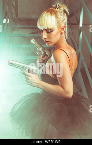 Cosplay, blonde avec des pistolets dans une usine abandonnée. cosplayeuse, d'action et femme dangereuse Banque D'Images
