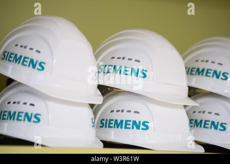 15 juillet 2019, Saxe, Görlitz : Blanc casques de protection avec la mention 'Siemens' sont sur une étagère dans un hall d'assemblage de l'usine de turbine Siemens. Photo : Sebastian Kahnert/dpa-Zentralbild/dpa Banque D'Images