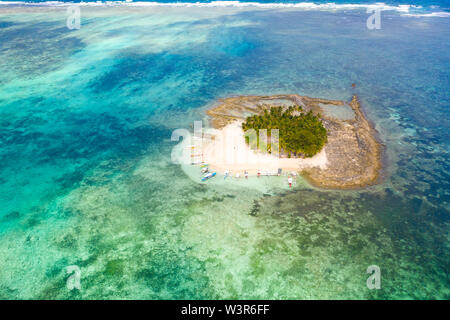 Petite île paradisiaque sur les récifs coralliens, vue du dessus. Guyam, l'île de Siargao, Philippines. Île tropicale avec palmiers et lagons. Des bateaux et des gens sur une petite île. Banque D'Images