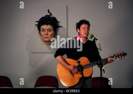 Un musicien joue en face de Méduse/bien-aimé, un chiffre réaliste par Sam Jinks qui fait partie de son exposition de sculptures dans la chair à la Galway International Arts Festival. Banque D'Images