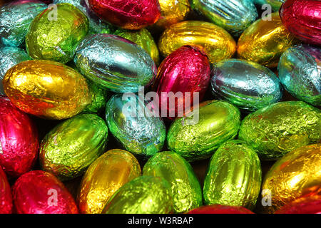 Oeufs de Pâques en chocolat fond feuilles colorées Banque D'Images