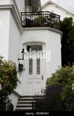 Une maison blanche avec porte ornée et balcon dans le prestigieux quartier Blankenese de Hambourg, Allemagne. Banque D'Images