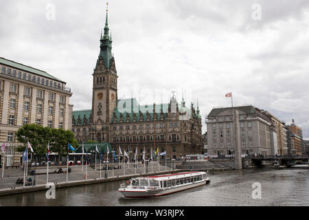 Un bateau visite la rivière Alster en passant par le Rathaus (hôtel de ville) sur le Rathaussmarkt dans le centre de Hambourg, en Allemagne. Banque D'Images