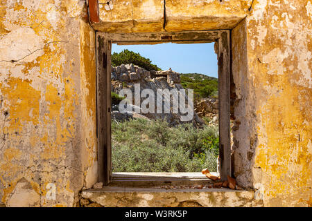 Vue de la fenêtre à l'intérieur des terres : la côte nord de la Sardaigne. Étude panoramique à partir d'une fenêtre à l'intérieur d'un bâtiment abandonné WW2, sur le bord de la falaise ; Baia Sardinia, Sardaigne Banque D'Images