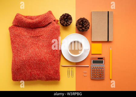 Articles de bureau et articles scolaires avec tasse à café, chandail, et des pommes de pin sur un fond jaune et orange. Mise à plat. Retour à l'école ou de bureau concept Banque D'Images