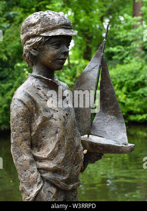 Statue de garçon avec étang location Pashley Manor Gardens. Banque D'Images