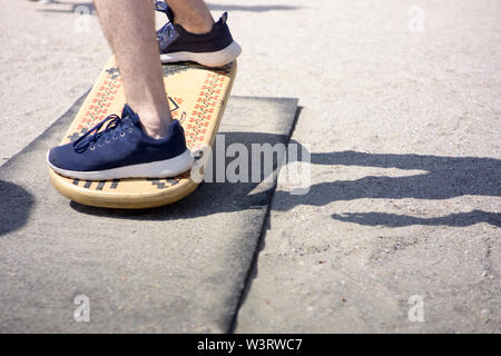 En équilibre sur une balance board par temps ensoleillé à la plage Banque D'Images