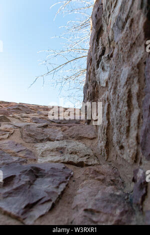 Une vue rapprochée du ciel depuis le bas d'un mur de pierre Banque D'Images