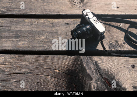 Gris et noir style vintage photo caméra sur table en bois à l'extérieur dans le soleil Vue de dessus Banque D'Images