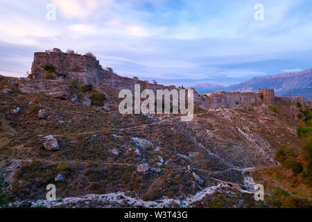 Vue de la forteresse à Gjirokaster l'Albanie, avec montagnes en arrière-plan au coucher du soleil sur une journée nuageuse. Banque D'Images