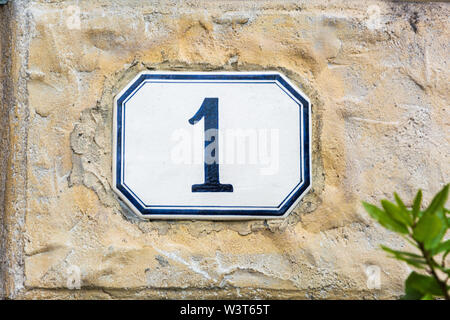 Numéro de maison une ( 1 ) sur un mur crépi Banque D'Images