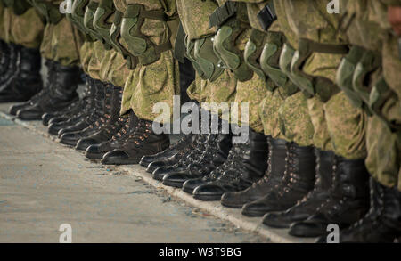 Construire un soldat en camouflage dans de hautes bottes. Les chaussures. Banque D'Images