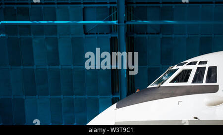 Le nez de l'appareil sur le fond bleu du hangar. Hublots avant Banque D'Images