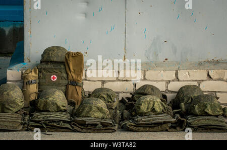 Les casques de l'armée se trouvent dans une rangée sur l'asphalte à côté de la trousse de premiers soins. Ambulance Banque D'Images
